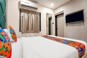 a bedroom with a white bed and a flat screen tv at Hotel 7 Star I in Surat