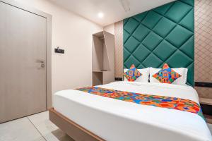 a bedroom with a large bed with a green headboard at Hotel 7 Star I in Surat