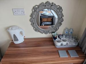 a mirror on top of a wooden table with a vanity at Greenlands Guest House in Highbridge +18 photos