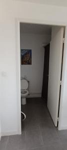 a white bathroom with a toilet in a room at Appartement katixa in Bayonne