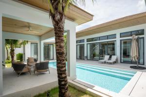 an exterior view of a villa with a swimming pool at Mouana Breeze Mai Khao 4-bedroom Pool Villa 9925 in Mai Khao Beach