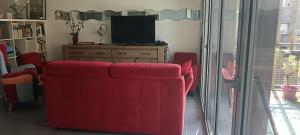 a living room with a red couch and a television at Appartement katixa in Bayonne