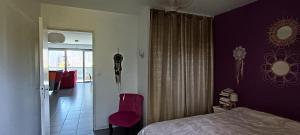 a bedroom with purple walls and a bed and a mirror at Appartement katixa in Bayonne