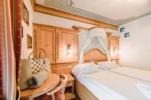 a bedroom with two beds and a table and a window at Hotel Des Alpes in Soraga +104 photos