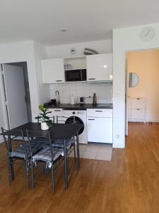 a kitchen and dining room with a table and chairs at Appartement Cosy, 30 minutes de Paris in Carrières-sous-Poissy