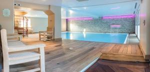 a large swimming pool in the middle of a room at La Closerie SPA & Résidence Hôtel in Deauville