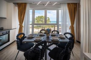 a dining room with a table and chairs and a window at Sea Breeze Chill Out Infinity Spa & Pool-parking in Mamaia Nord