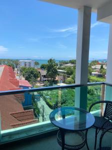 a balcony with a table and chairs and the ocean at The Gallery Condominium M in Jomtien Beach