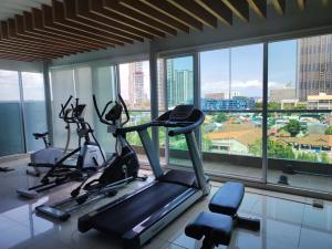 a gym with three exercise bikes in a room with windows at The Gallery Condominium M in Jomtien Beach