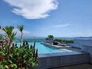 a swimming pool with a view of the ocean at The Gallery Condominium M in Jomtien Beach