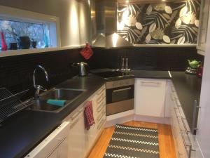 a kitchen with a sink and a stove at Bella Luna Strandnära in Skummeslövsstrand