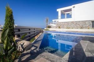 a swimming pool in front of a house at Villa Deja Blu with Private Pool in Kalogrea