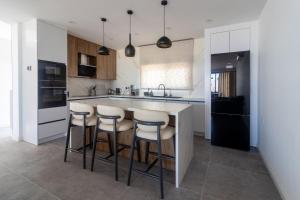 a kitchen with a island with bar stools at Villa Deja Blu with Private Pool in Kalogrea