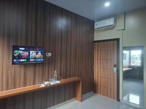 a room with a television on a wall with a counter at Hotel Ruang Tidur in Stasiun Tawang