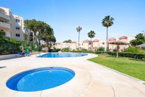 a swimming pool in a yard with palm trees at Secret View Riviera Del Sol in Sitio de Calahonda