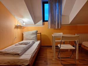 a bedroom with a bed and a table and a chair at 2-Rent Group Hostel Rooms AUB162 in Munich