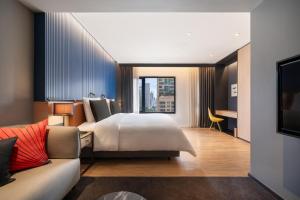 a hotel room with a bed and a couch at Sindhorn Midtown Hotel Bangkok, Vignette Collection by IHG in Bangkok