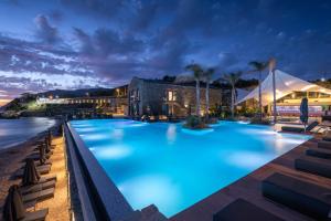 a large swimming pool with blue lighting in front of a building at Porto Plomari in Plomari