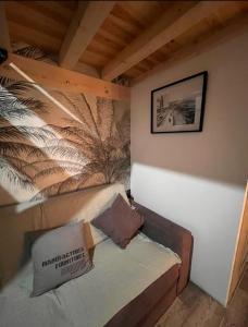 une petite pièce avec un canapé et un mur avec une fresque de plumes dans l'établissement Atelier, à Saint-Mandrier-sur-Mer