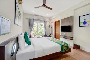 a bedroom with a large white bed and a window at Treebo Pratham Inn, Manipal in Udupi +39 photos