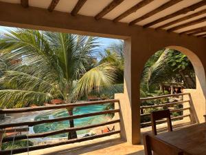 a balcony with a view of the ocean and palm trees at Lapili Residence in Kiwengwa