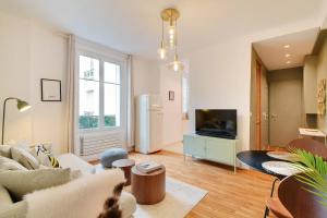 a living room with a couch and a tv at Calm Square Flat in Boulogne-Billancourt
