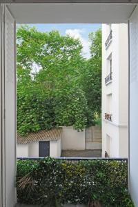 a view from a window of a building with a tree at Calm Square Flat in Boulogne-Billancourt