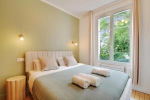 a bedroom with a large bed with two towels on it at Calm Square Flat in Boulogne-Billancourt
