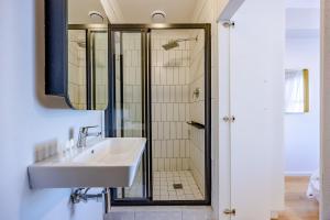 un baño con lavabo y ducha en Modern 2 bed, 2 bath- Blouberg, en Bloubergstrand 47 fotos más