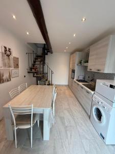 a kitchen and dining room with a table and a washing machine at La casa del cuore in Montefiascone