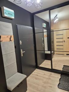 a room with mirrored walls and a mirror and a room with a room at Gold Premium Apartment in Suwałki