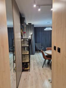 a dining room with a table and a shelf with wine glasses at Gold Premium Apartment in Suwałki