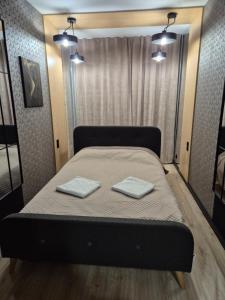 a bed in a room with two towels on it at Gold Premium Apartment in Suwałki