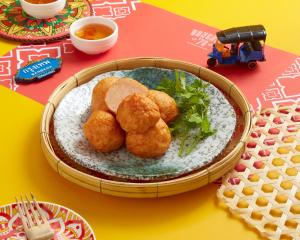 a plate of food with meatballs and greens on a table at Sindhorn Midtown Hotel Bangkok, Vignette Collection by IHG in Bangkok