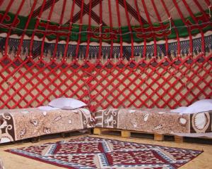 a room with two beds in a yurt at AiSun Eco Yurt Camp in Tossor