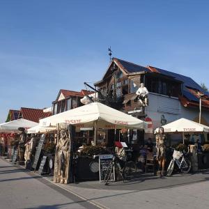 a building with umbrellas and people sitting at tables at Apartamenty w Helu in Hel