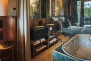 a bathroom with a tub and a sink and a bath tub at Van Oys Maastricht Retreat, a Leading Hotel of the World in Eijsden +50 photos