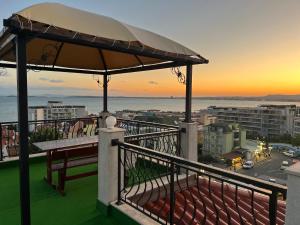 a balcony with a bench and an umbrella at Villa Antorini in Sveti Vlas