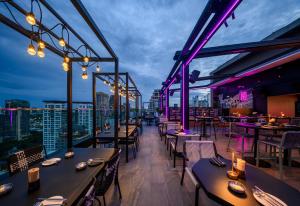 a restaurant with tables and chairs on a roof at Sindhorn Midtown Hotel Bangkok, Vignette Collection by IHG in Bangkok