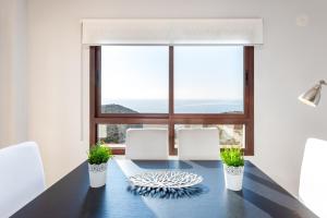 a dining room with a table and a large window at Villa Margarita in Vélez-Málaga