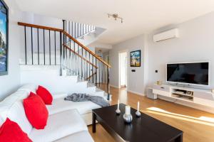 a living room with a white couch and red pillows at Villa Margarita in Vélez-Málaga