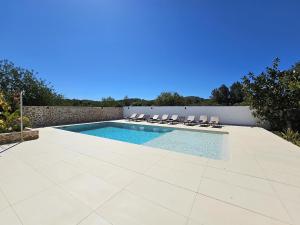 basen z krzesłami przy ścianie w obiekcie INIBIZA VILLAS - Villa Bello w mieście San Antonio