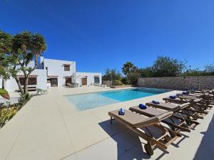 szereg leżaków przy basenie w obiekcie INIBIZA VILLAS - Villa Bello w mieście San Antonio