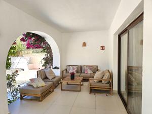 salon z kanapą, krzesłami i łukiem w obiekcie INIBIZA VILLAS - Villa Bello w mieście San Antonio +37 zdjęć