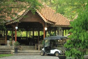 un carro de golf estacionado frente a un edificio en Villa Couple by Santosa Stable Resort, en Gunungpati