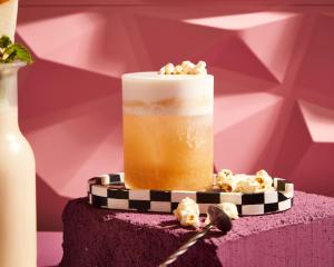 a drink on top of a purple table with popcorn at Sindhorn Midtown Hotel Bangkok, Vignette Collection by IHG in Bangkok