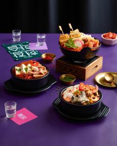 a purple table with plates of food and bowls of food at Sindhorn Midtown Hotel Bangkok, Vignette Collection by IHG in Bangkok