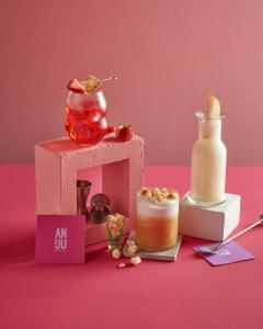 a pink table with a small house and a bottle of syrup at Sindhorn Midtown Hotel Bangkok, Vignette Collection by IHG in Bangkok