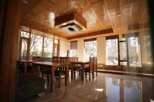 ein Esszimmer mit Tisch und Stühlen und Fenstern in der Unterkunft Wooden Castle Hotel and Resort in Manali