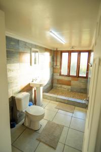 a bathroom with a toilet and a sink and a shower at Sunset Lodge in Miramar +47 photos